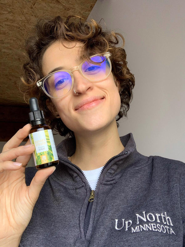 Zufriedene Kundin zeigt NATURTREU Sonnenfreund Vitamin D3 K2 Tropfen. 