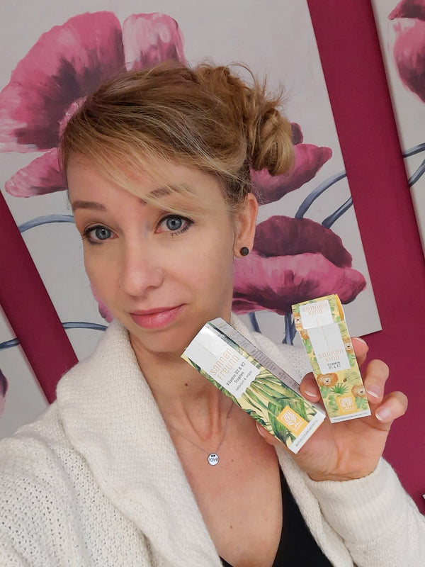Zufriedene Kundin zeigt NATURTREU Sonnenfreund Vitamin D3 K2 Tropfen. 