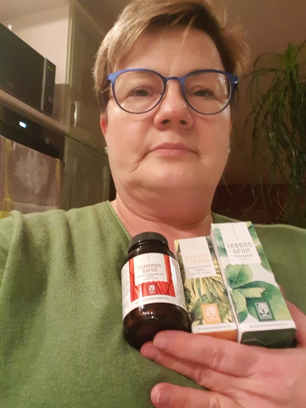 Zufriedene Kundin zeigt NATURTREU Sonnenfreund Vitamin D3 K2 Tropfen. 