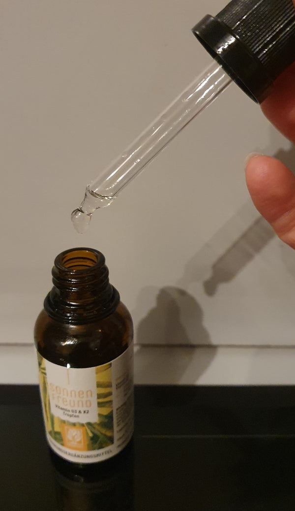 Zufriedene Kundin / zufriedener Kunde zeigt NATURTREU Sonnenfreund Vitamin D3 K2 Tropfen.