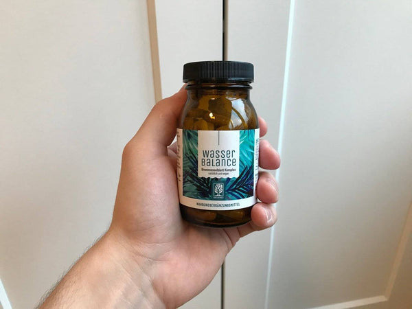 Zufriedene Kundin / zufriedener Kunde zeigt NATURTREU Brennnessel Kapseln. 